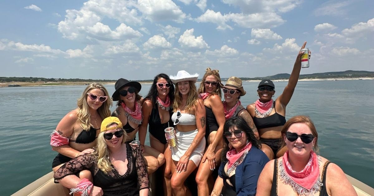 Friends pose on a pontoon boat in lake travis for bachelorette